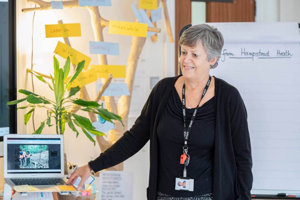 A picture of a Southbank International teacher standing next to a white board