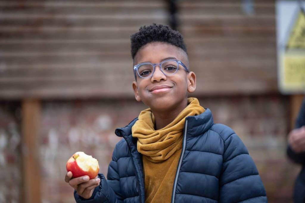 A happy student eating an apple