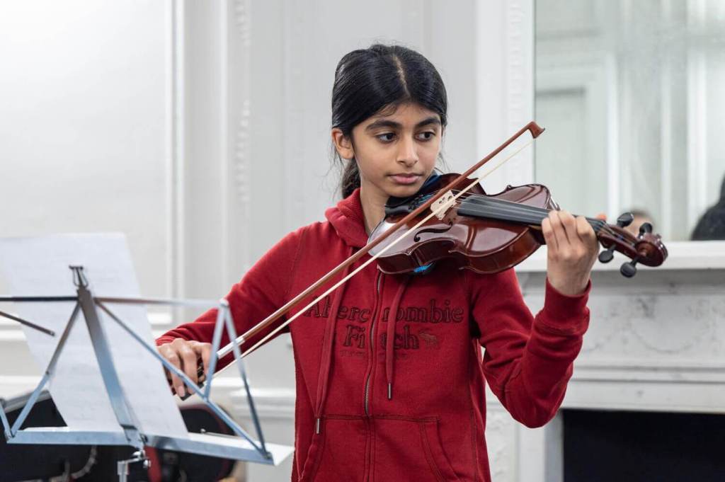 A young girl playing a violin