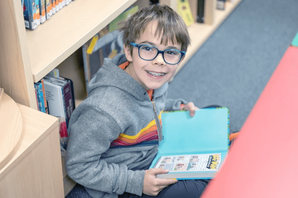 Child smiling whilst reading book