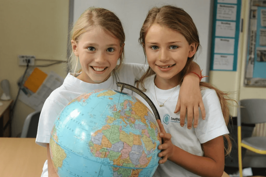 two smiling girls with globe