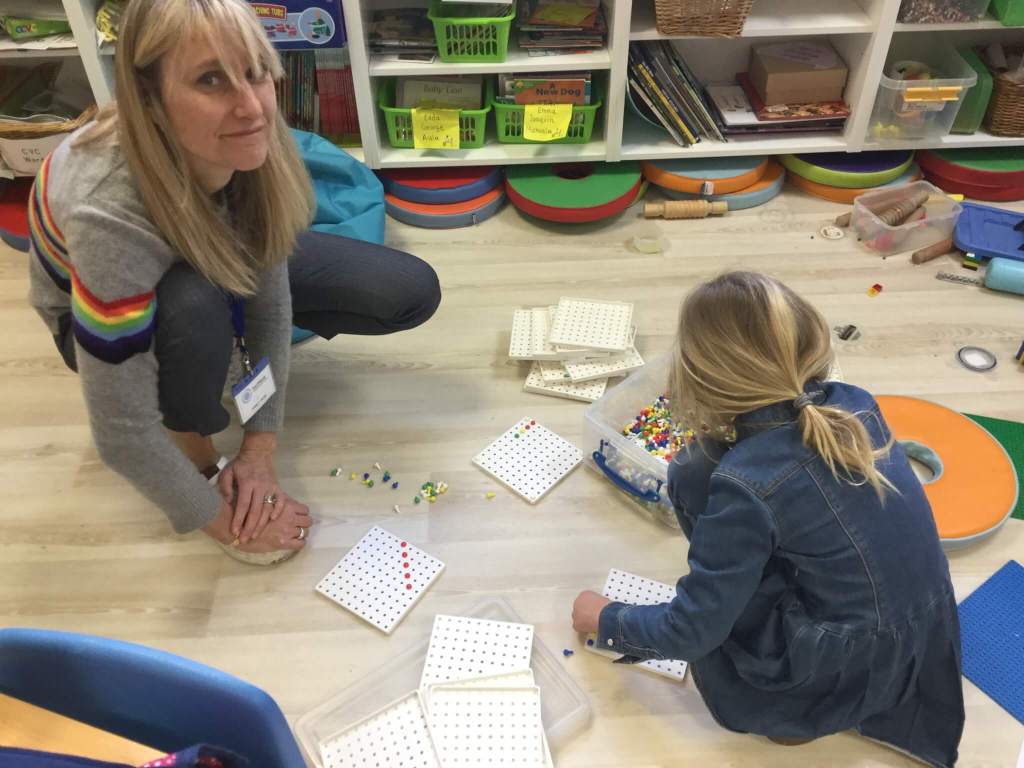teacher and child doing maths together (play)